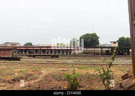 Bahnhofshof der Nigerian Railway Corporation in Enugu, Nigeria, zeigt verlassene Gleise und Güterwagen unter bewölktem Himmel, März 2025 Stockfoto