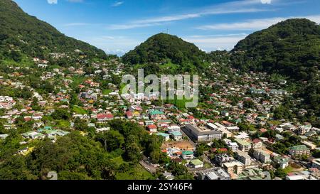 Stadt eingebettet in üppige grüne Hügel unter einem klaren blauen Himmel. Victoria. Seychellen, Mahe. Stockfoto