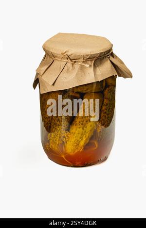 Ein Glas voller hausgemachter eingelegter Gurken und Tomaten zeigt leuchtende Farben. Der Inhalt wird in eine aromatische Salzlake getaucht, die zum Genießen bereit ist Stockfoto