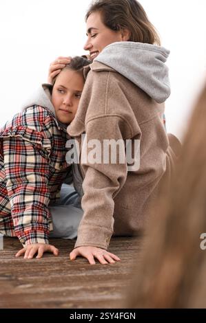 Mutter und Tochter sitzen am Strand Stockfoto
