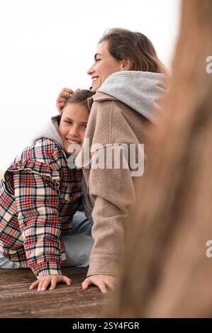 Mutter und Tochter sitzen am Strand Stockfoto