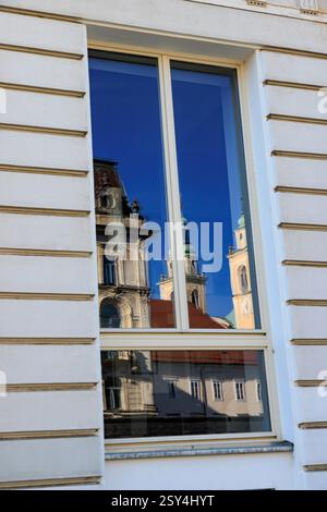 Eine Reflexion der historischen Gebäude und Türme der Kathedrale in Ljubljana in einem Fenster. Ein wunderschöner Blick auf Sloweniens Hauptstadt, der die architektonische Stockfoto