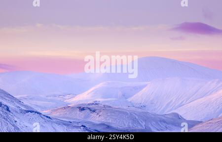 Sonnenuntergang über den Bergen der Highlands in Island an einem kalten Wintertag mit wunderschönen Farben am Himmel Stockfoto