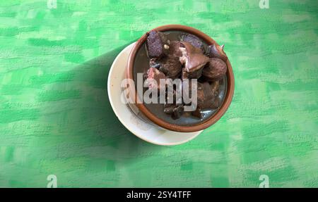 Traditionelles brasilianisches Mittagessen mit gegrilltem Schweinefleisch, Feijoada, Reis, Farofa und Kohlgemüse, serviert auf einer karierten Tischdecke Stockfoto
