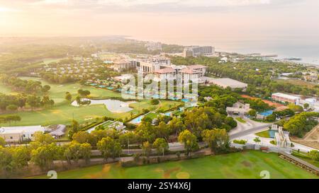 Panoramablick auf ein luxuriöses Baderesort mit Golfplätzen, privaten Villen und Pools bei Sonnenaufgang Stockfoto