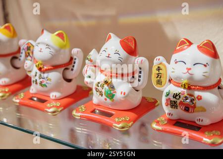 Nahaufnahme von maneki-neko (anwinkende Katze). Eine Reihe japanischer Figuren in einem Souvenirladen am Central Market Stockfoto