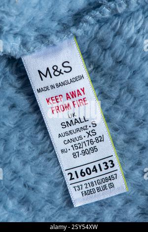 M&S Label, hergestellt in Bangladesch, von Feuer fernhalten, Kleideranhänger in einem Fleece-Morgenmantel Stockfoto