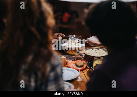 Freunde genießen ein gemütliches Abendessen mit köstlichem Essen und Unterhaltung Stockfoto