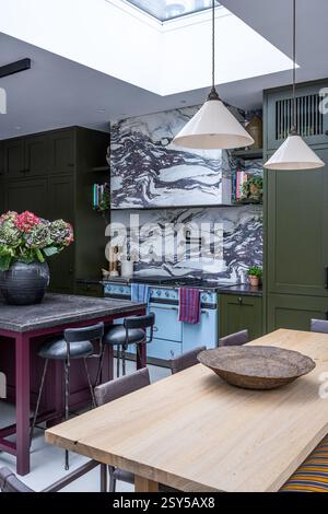 Hängeleuchten über dem Tisch mit Aubergine- und olivgrüner Lackierung im zeitgenössischen Neudesign des Hauses West London. Stockfoto