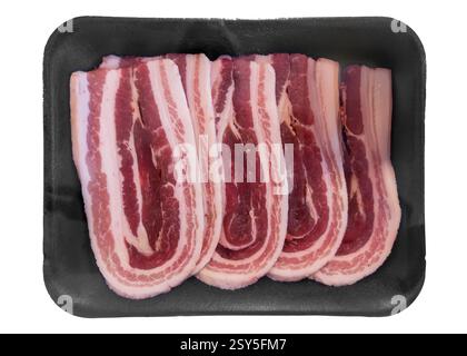 Frischer Schweinebauch zum Grillen, Speckscheiben verpackt in einer schwarzen Kunststoffschale, isoliert auf weiß, mit Schneidepfad enthalten Stockfoto