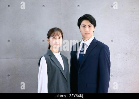 Japanischer Junger Mann Und Frau In Geschäftskleidung Stehen Nebeneinander Stockfoto