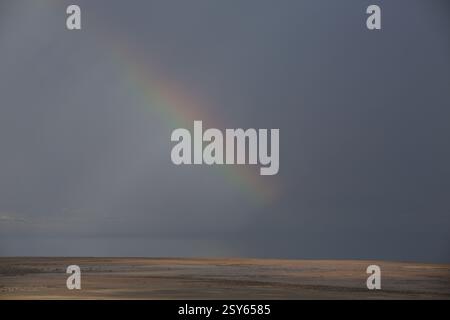 Regenbogen und ein Lichtspiel am bewölkten Himmel an einem regnerischen Tag über Qumran und dem Toten Meer, dem See, seinem Wasser und seinem Ufer. Stockfoto