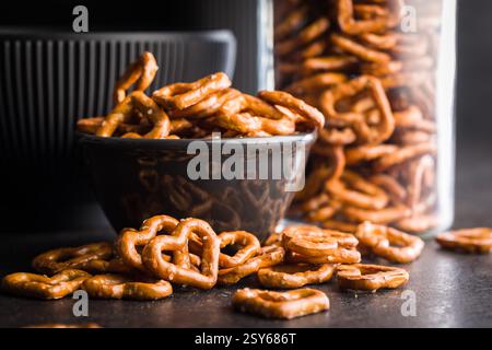 Herzförmige Brezel in Schüssel auf einem schwarzen Tisch. Stockfoto