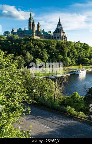 Die große Burg liegt auf einem Hügel mit einem See im Hintergrund. Die Burg ist von Bäumen umgeben und ein Pfad führt zu ihr Stockfoto