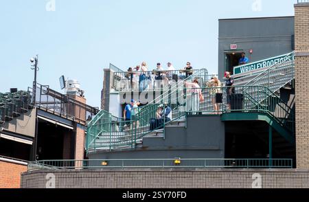 Chicago, Illinois, USA - 19. Juli 2024: Fans genießen einen sonnigen Tag im Wrigley Field, bei dem sie sich auf der Tribüne treffen, um das Baseballspiel zu beobachten. Stockfoto