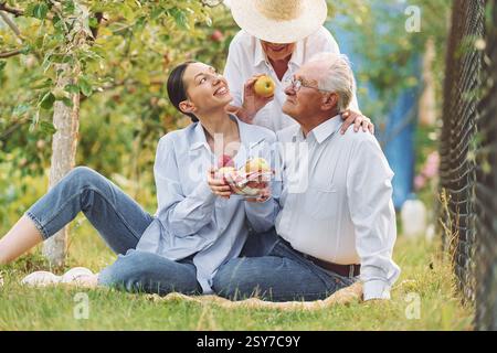 Auf dem Boden sitzen. Die Tochter ist bei ihrer älteren Mutter und der Vater ist im Garten. Stockfoto