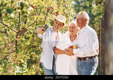 Die Frau macht Selfie. Die Tochter ist bei ihrer älteren Mutter und der Vater ist im Garten. Stockfoto