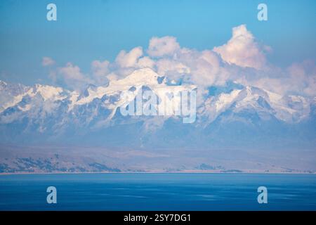 Atemberaubende Landschaft des Titicacasees mit majestätischen schneebedeckten Anden in der Ferne an einem sonnigen Tag Stockfoto
