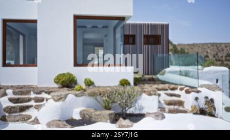 Modernes Haus mit verschwommenem Fokus, zeitgenössischem architektonischen Design, großen Fenstern und einer Außentreppe, die zu einem Glaspool führt Stockfoto