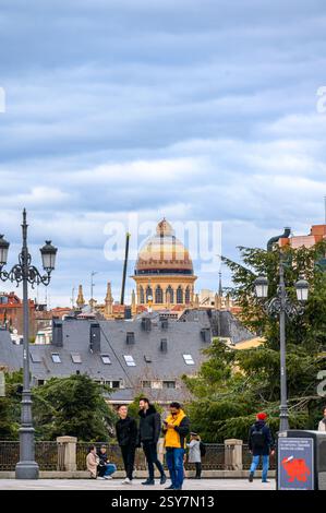 Menschen auf einem Platz mit der byzantinischen Kuppel der Kirche Santa Teresa y San Jose im Hintergrund, Madrid, Spanien Stockfoto