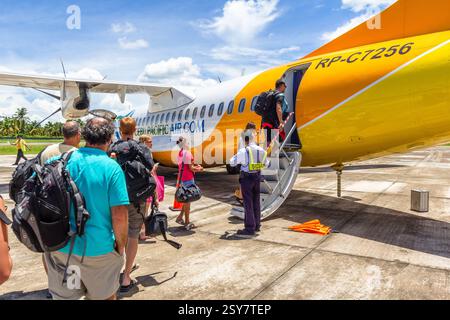 Passagiere besteigen ein Cebu Pacific Flugzeug direkt vom Asphalt am Sayak Airport in Siargao, Philippinen Stockfoto