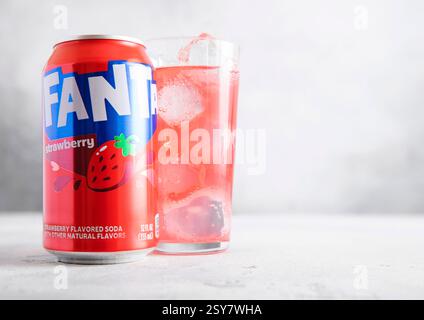 LONDON, UK - 27. FEBRUAR 2025: Erfrischungsgetränk Fanta Erdbeere mit Glas mit Eiswürfeln auf hellem Hintergrund. Stockfoto
