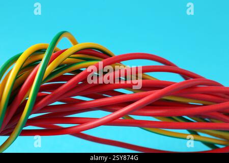 Viele farbige elektrische Drähte auf hellblauem Hintergrund, Nahaufnahme Stockfoto