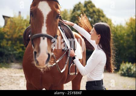 Seitenansicht. Junge schöne Frau mit Pferd ist draußen. Stockfoto
