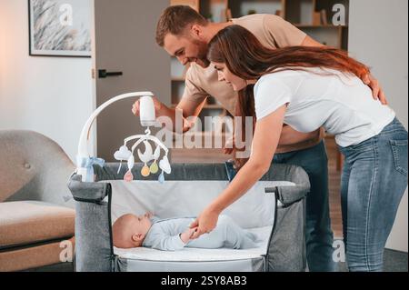 In der Ladestation. Nettes Paar, das sich um das Neugeborene im Haus kümmert. Stockfoto