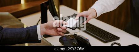 Website-Banner mit nicht erkennbarer, empfindlicher weiblicher Hand, die den Reisepass in schwarzem Lederbezug und die Schlüsselkarte an Hotelgäste zurückgibt Stockfoto