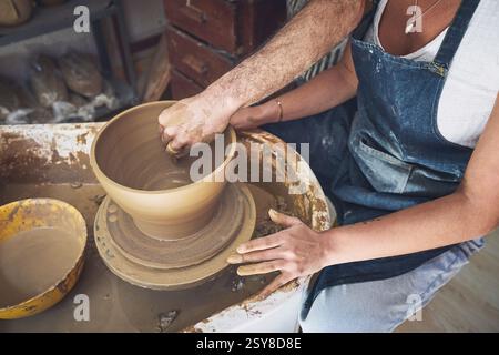 Klasse, Hände und Menschen mit Keramikrad, Ton oder Talent für handgefertigte Produkte, Lehrer oder Prozesse. Lektion, Kreativität und Fertigkeiten für die Produktion von Stockfoto