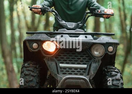 Vorderansicht. ATV-Fahrer ist im Wald und fährt tagsüber. Stockfoto
