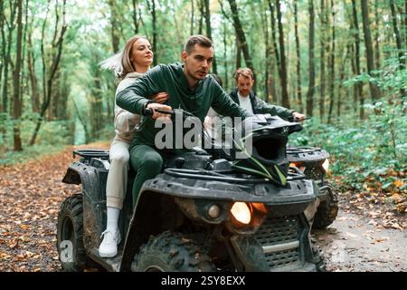 Reiten und lächeln. Ein junges Paar, das im Wald mit dem Quad fährt. Stockfoto