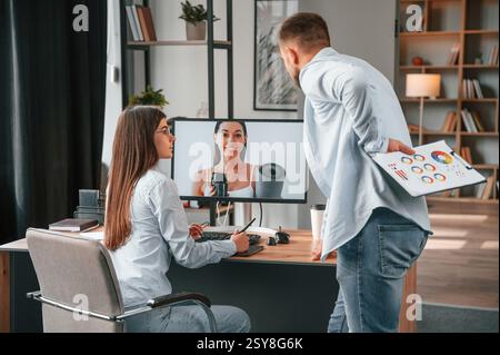 Das Porträt der Frau retuschieren. Zwei junge Designer arbeiten im Büro zusammen. Stockfoto