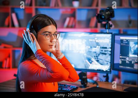 In Kopfhörern. Junger, schöner Game-Streamer ist drinnen mit pc. Stockfoto