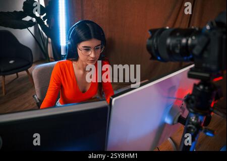 Die professionelle Kamera nimmt die Frau auf. Junger, schöner Game-Streamer ist drinnen mit pc. Stockfoto