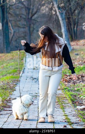 Junge Frau mit einer Tasse Kaffee und niedlichem Jack Russel Terrier im Park Stockfoto
