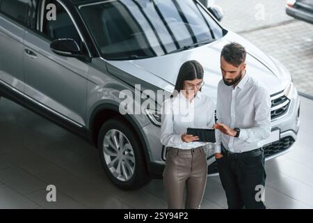Draufsicht. Mann mit Frau in weißer Kleidung ist zusammen im Autohaus. Stockfoto
