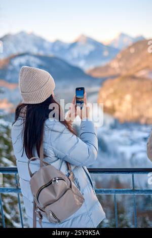 Dieses hochauflösende Foto zeigt eine junge Frau, die draußen in einer ruhigen, schneebedeckten Landschaft steht. Leicht links vom im positioniert Stockfoto