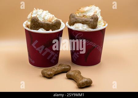 Zwei Tassen Kaffee mit Hundekeksen drauf Stockfoto