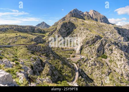 Die gewundene Bergstraße schlängelt sich durch das felsige Gelände der Serra de Tramuntana, mit dem majestätischen Gipfel Puig Major im Hintergrund. Mallorca, Balearen Stockfoto