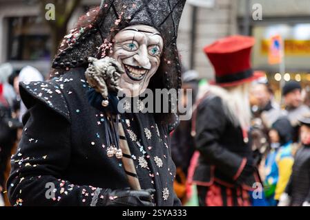 Luzern, Schweiz. Februar 2025. Ein Teilnehmer mit großer Maske nimmt an der Fritschi-Parade in Luzerner Fasnacht Teil. Die Parade bietet Originalkostüme, lebhafte Darbietungen und festliche Straßenfeste. Quelle: Fabienne Koch/Alamy Live News Stockfoto
