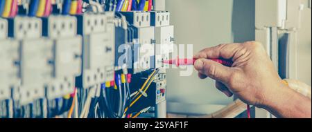 Elektroingenieur überprüft die Funktion des elektrischen Schaltschranks. Stockfoto