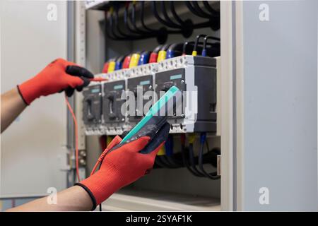 Elektroingenieur überprüft die Funktion des elektrischen Schaltschranks. Stockfoto