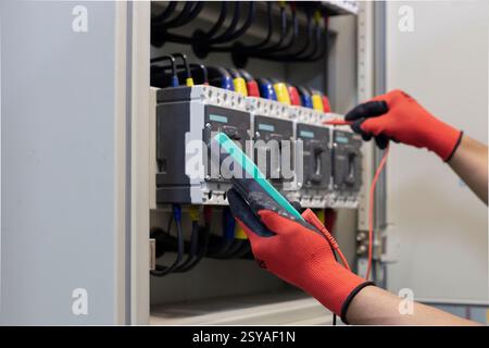 Elektroingenieur überprüft die Funktion des elektrischen Schaltschranks. Stockfoto