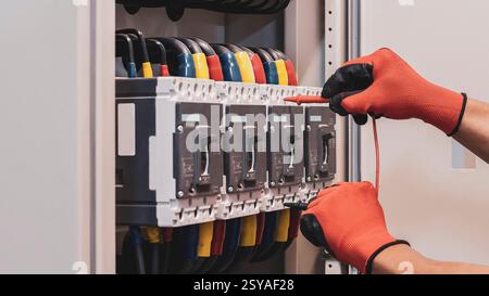 Elektroingenieur überprüft die Funktion des elektrischen Schaltschranks. Stockfoto