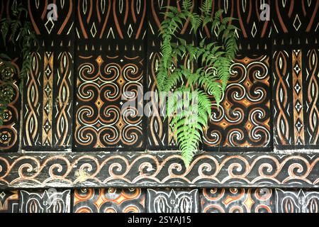 Farnblatt und dekoratives Gemälde in traditionellem Motiv an der Wand einer Reisscheune im Dorf Kete Kesu, Nord-Toraja, Süd-Sulawesi, Indonesien. Stockfoto