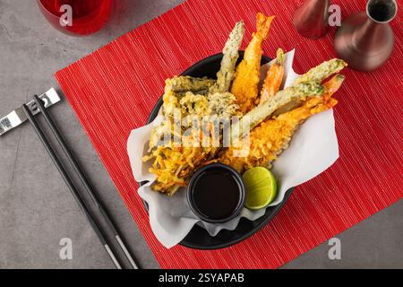 Garnelentempura mit Gemüsetempura auf schwarzer Keramikplatte Stockfoto