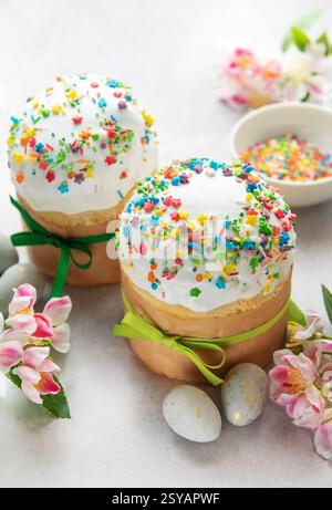 Traditionelle osterkuchen, dekoriert mit bunten Streuseln und begleitet von bemalten Eiern, feiern die Ankunft des Frühlings Stockfoto