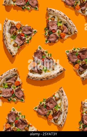 Blick von oben auf köstliche Pizzascheiben, geschmackvoll garniert mit Roastbeef, Trüffelsauce, Mozzarella, Stachelpilzen und frischen Kirschtomaten. Jede s Stockfoto
